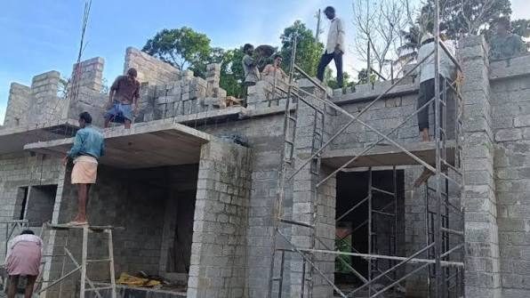 Workers on rooftop building block walls